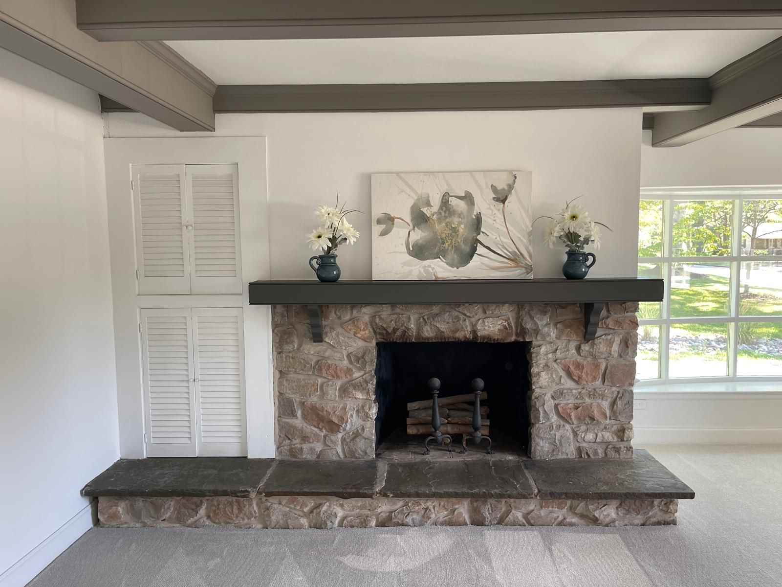 A stone fireplace with a dark mantel