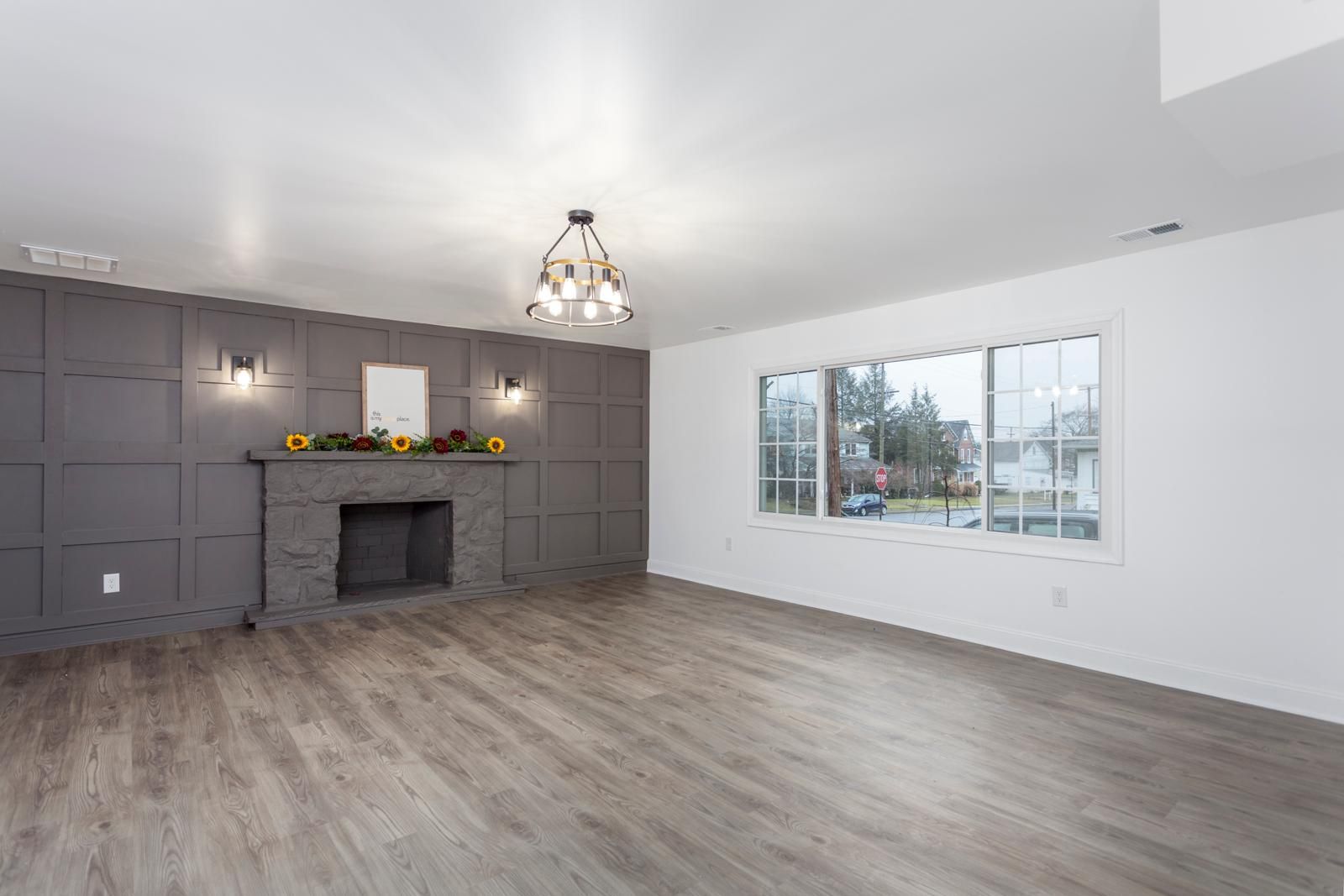 A lower-level room with a dark fireplace wall