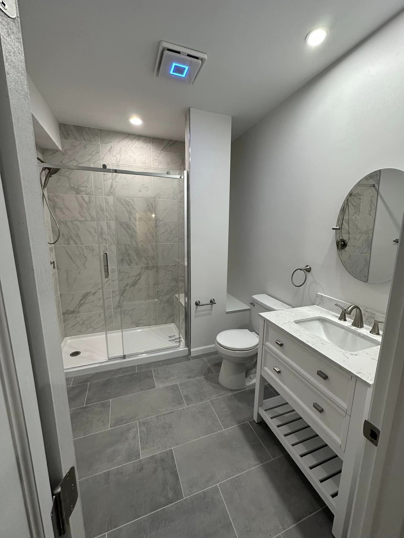 A gray vanity and a tiled shower