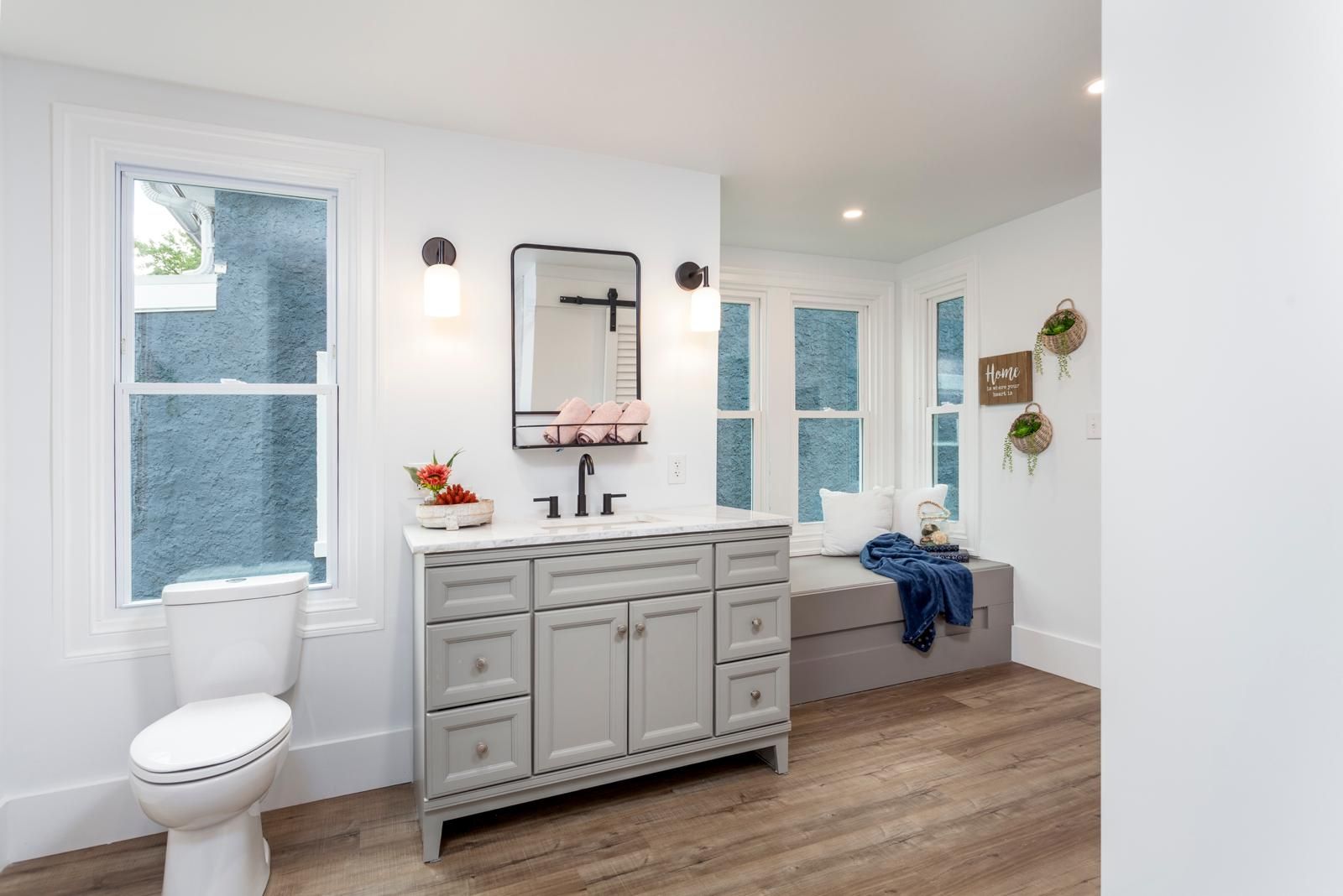 A gray vanity with a black-framed mirror