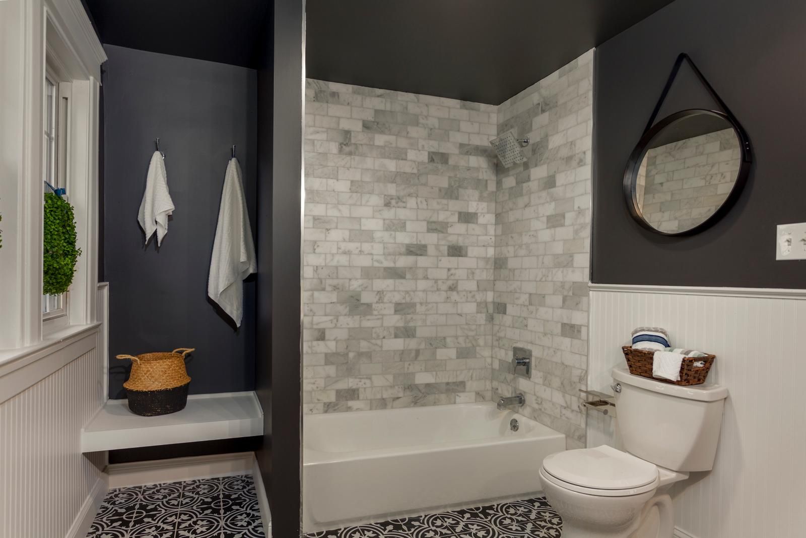 A navy bathroom with a subway-tile tub surround