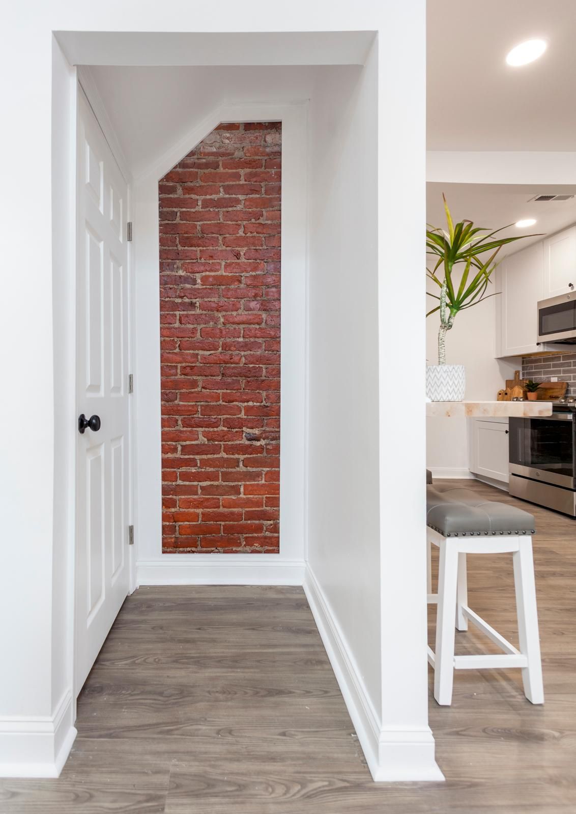 An exposed brick niche beside a doorway