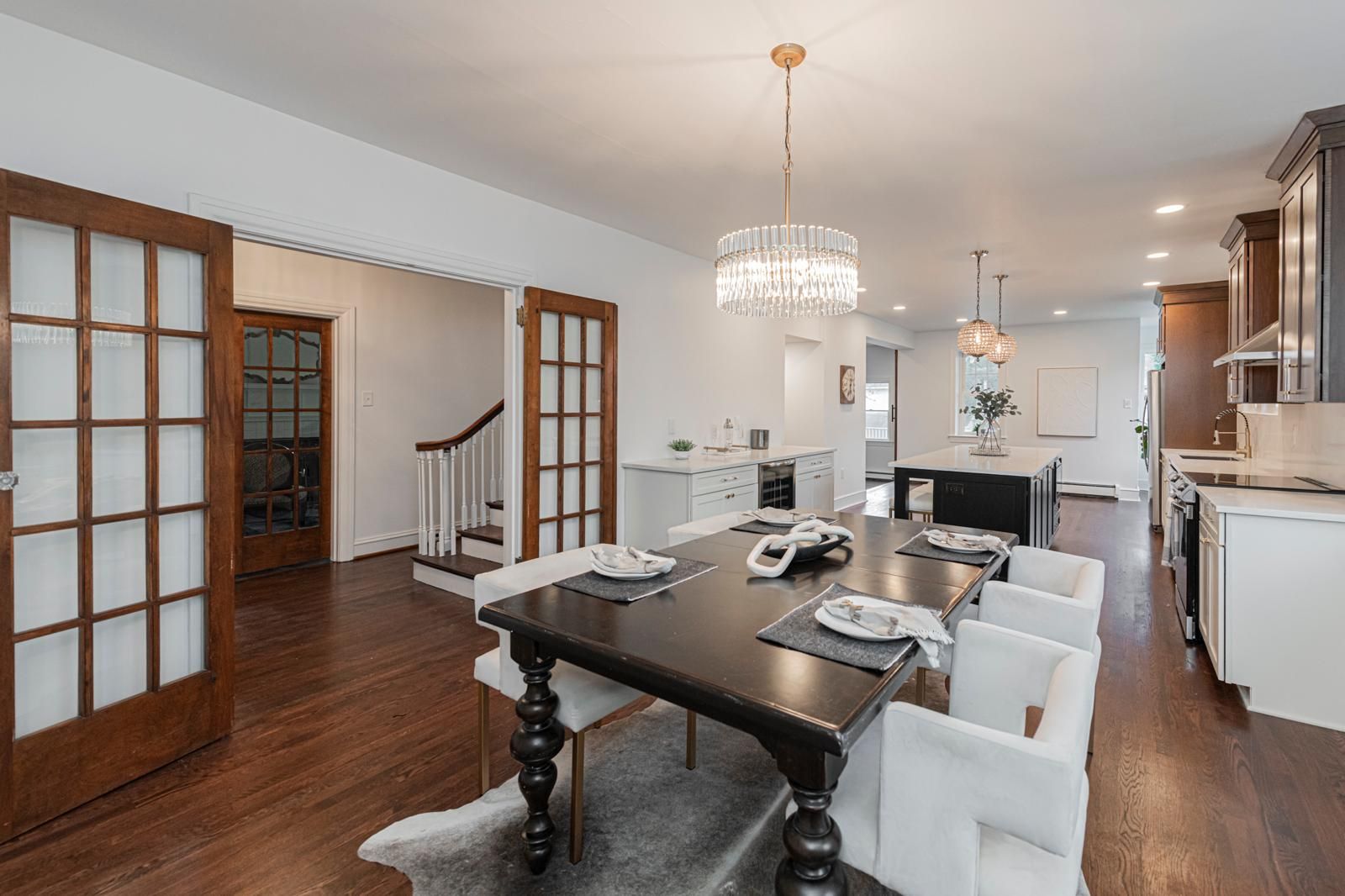A dining room with french doors and a pendant