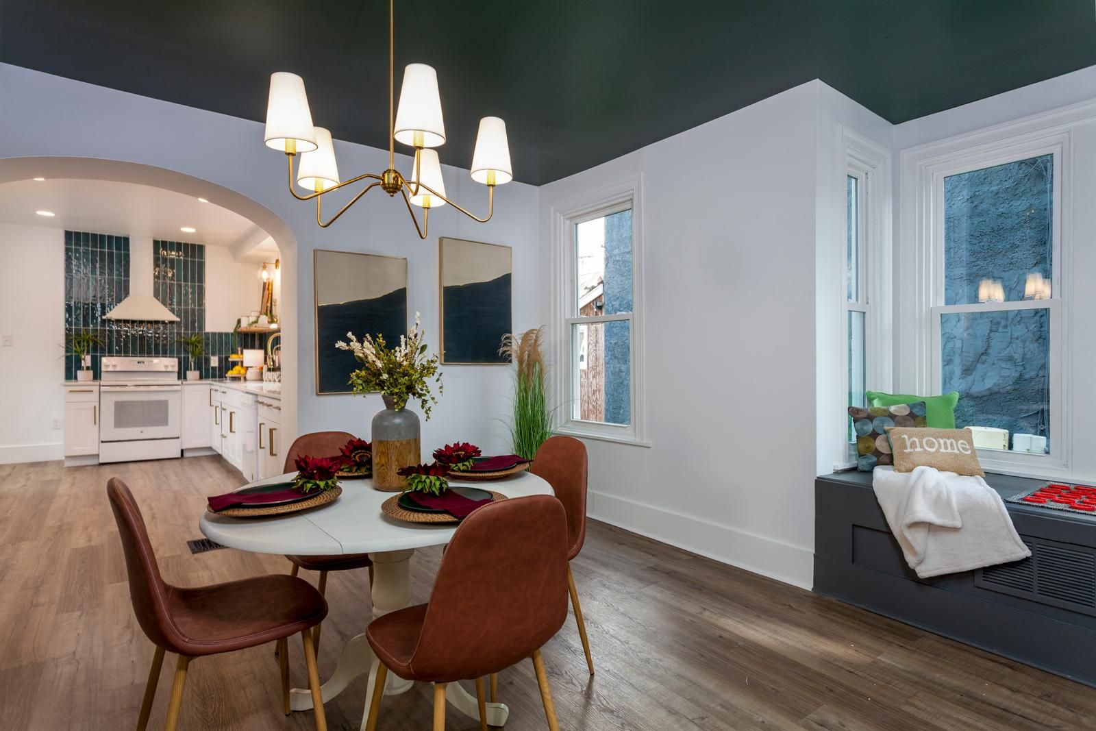 A dining room with a lantern chandelier and orange chairs