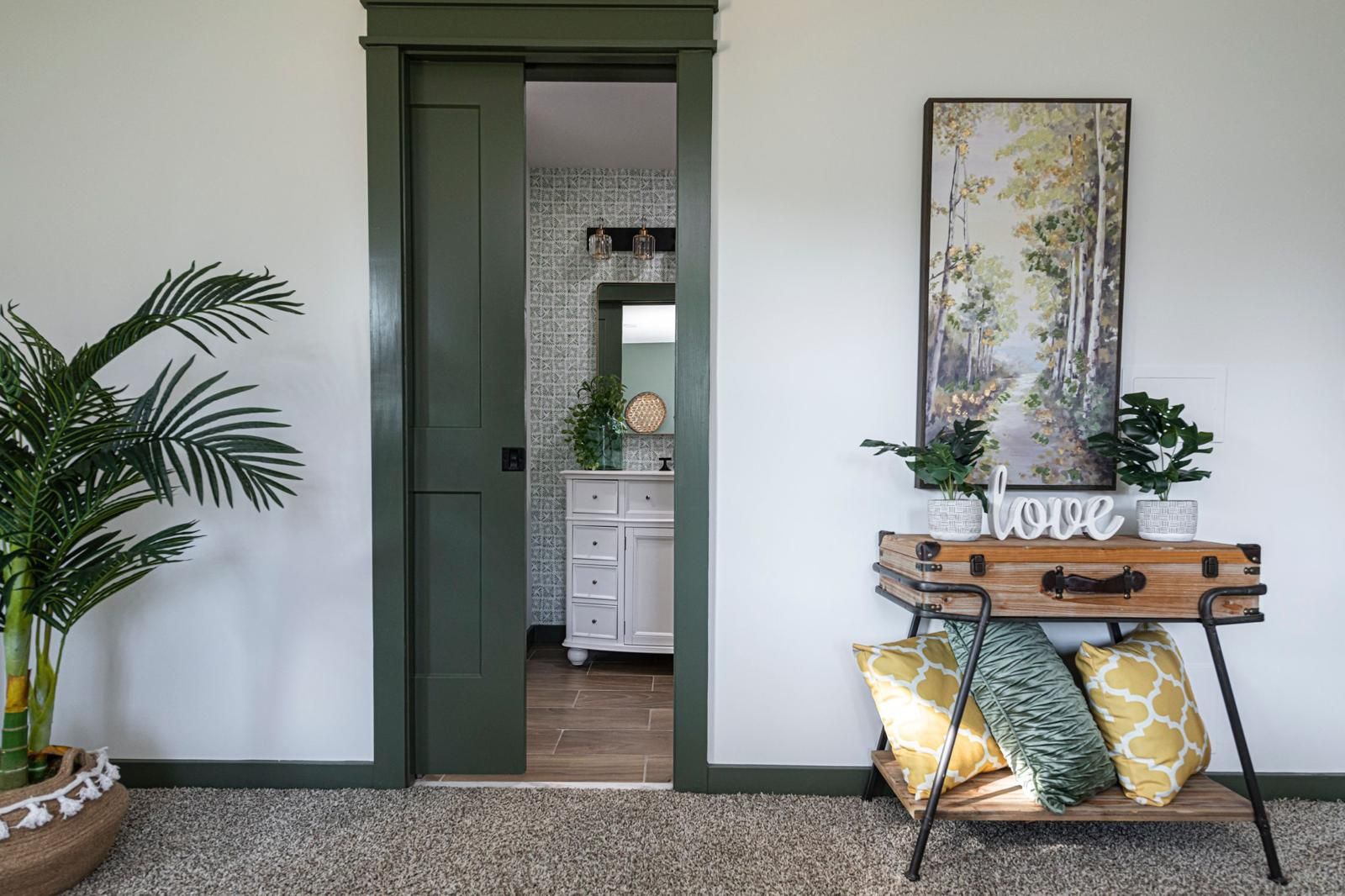 A doorway trimmed in green, a palm beside it