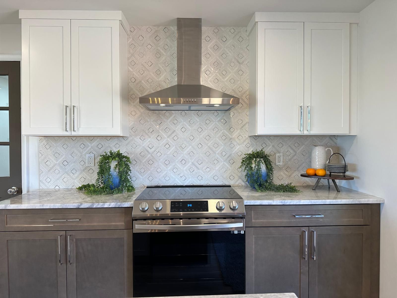 A chevron tile backsplash behind a stainless range