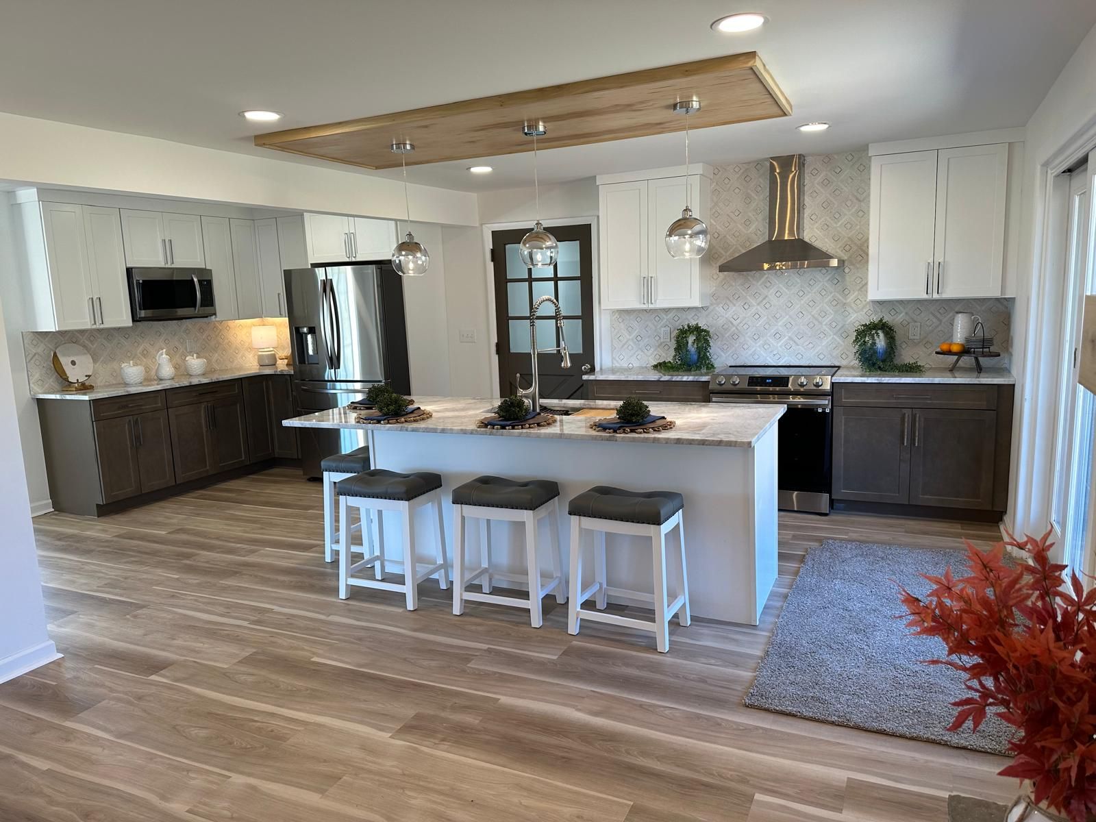 A kitchen island with counter stools by the window