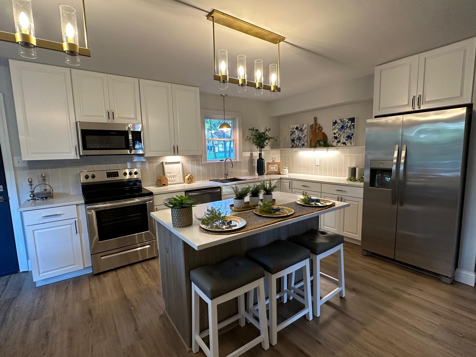 A white kitchen with a range and a full-height fridge