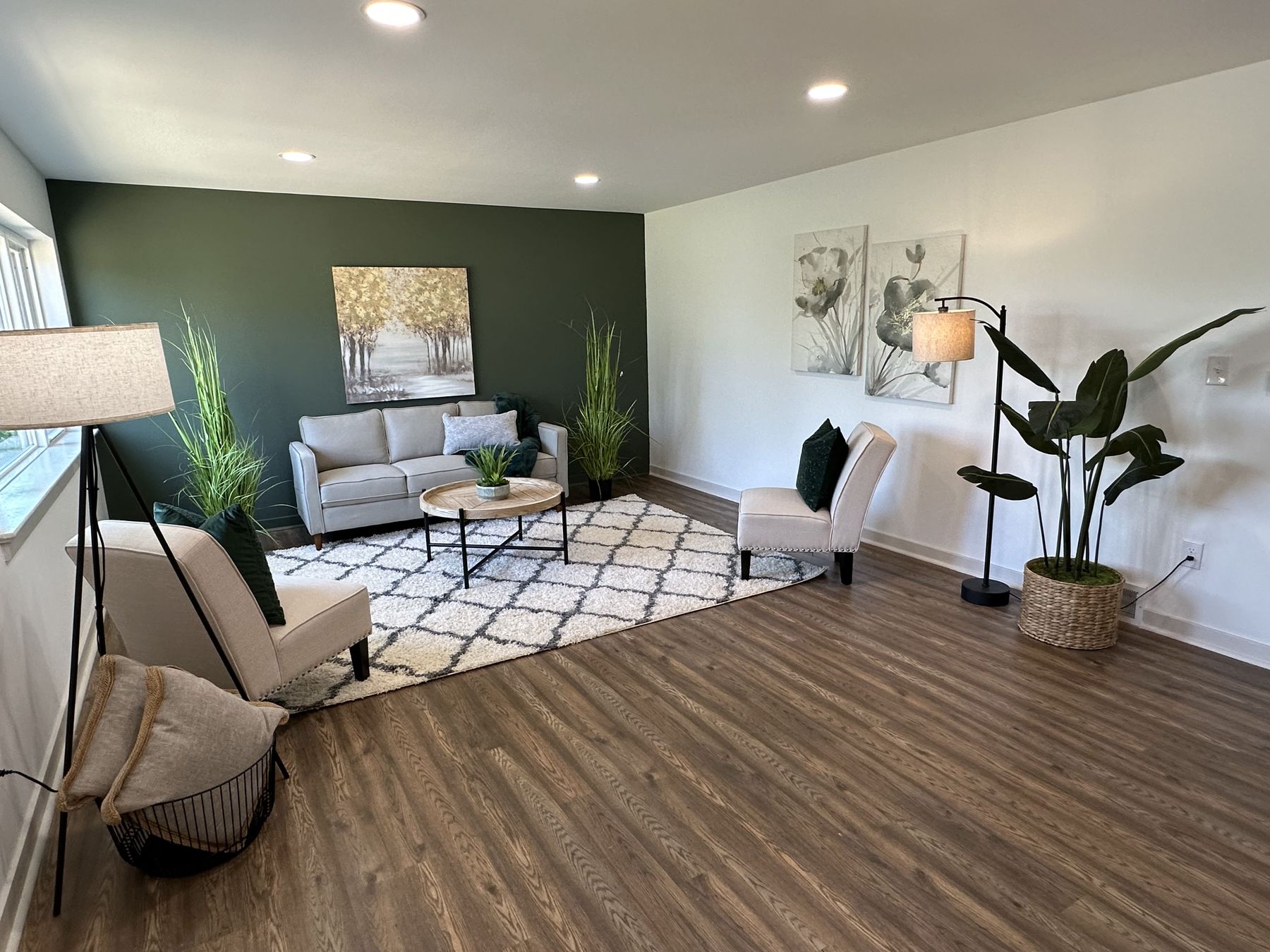 A living room with dark green walls and a patterned rug
