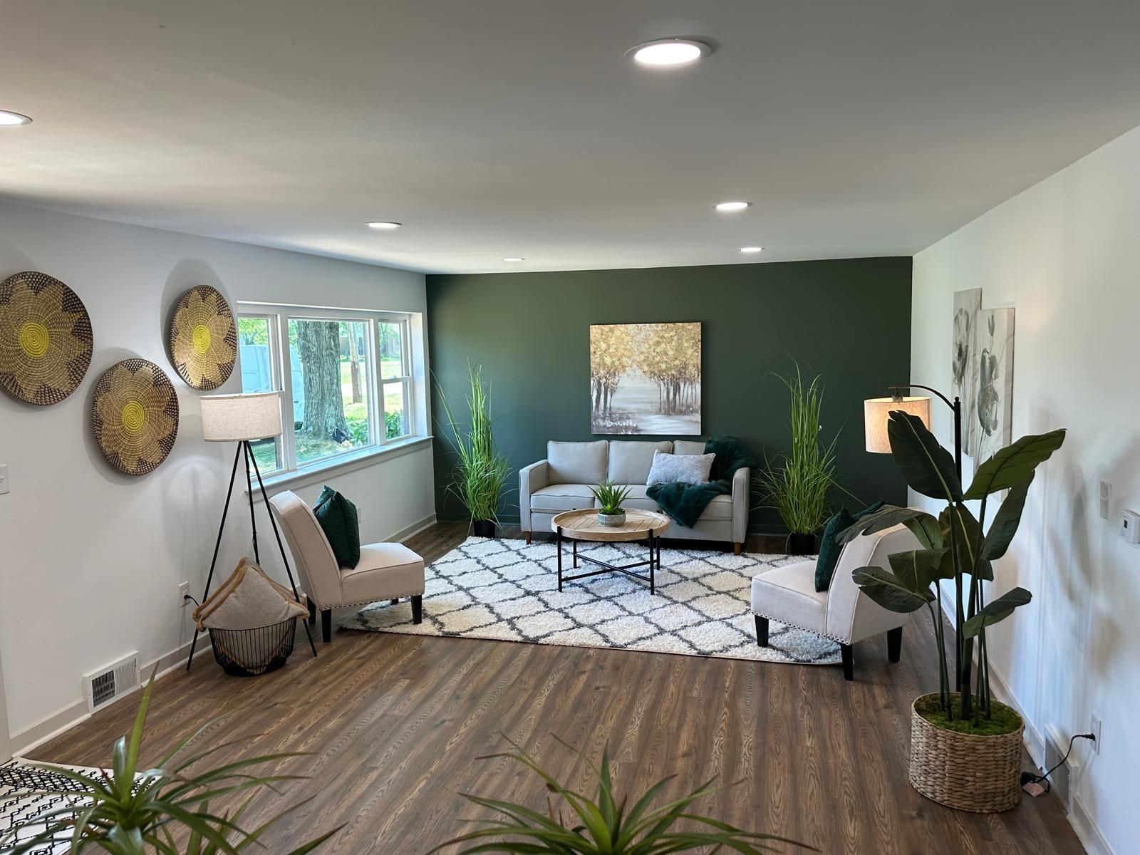 A living room with a green accent wall and recessed lighting